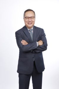an older man wearing a black suit and glasses while smiling