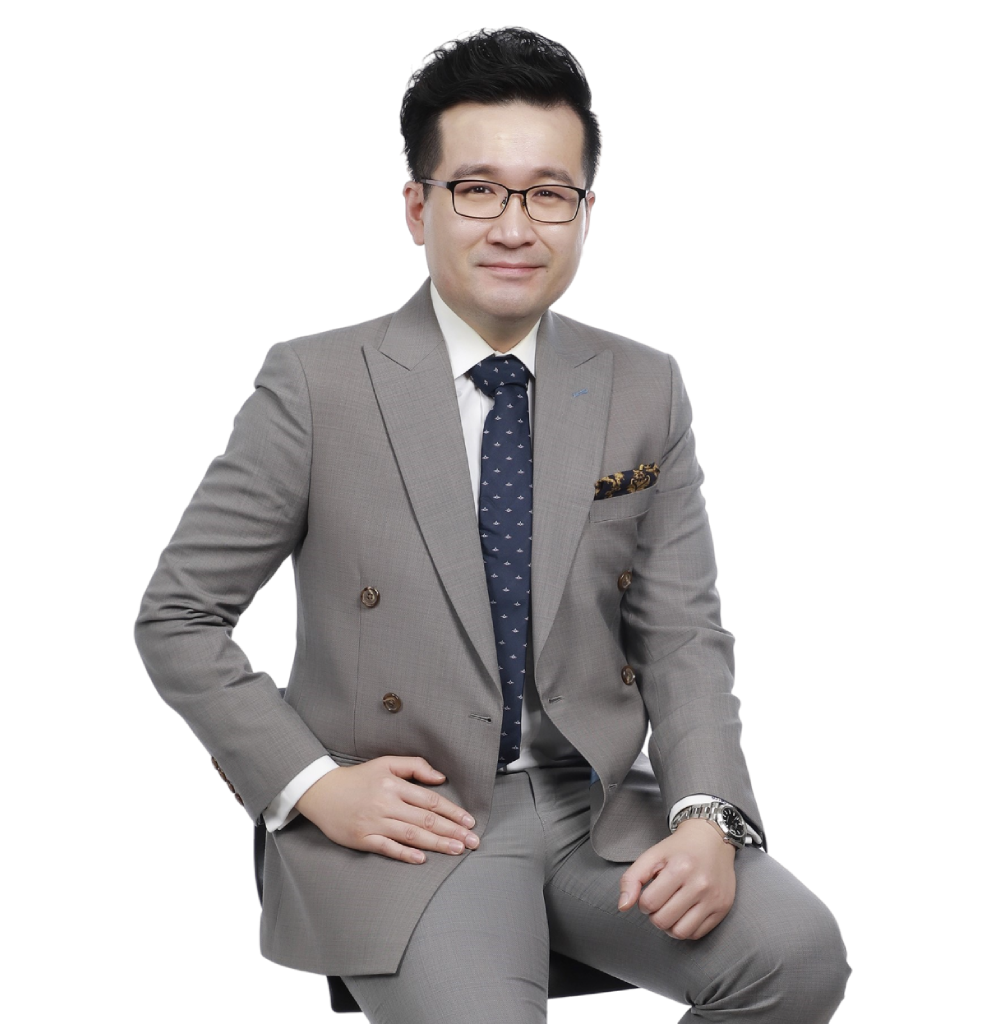 an asian man with a grey suit sitting on a chair
